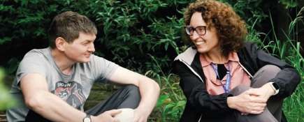 Photo of Mark with Debbie from Leeds ICB. They are sitting outside chatting.