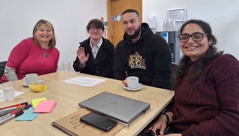 Malina pictured at a table with colleagues Alice, Kieron and Rabab.