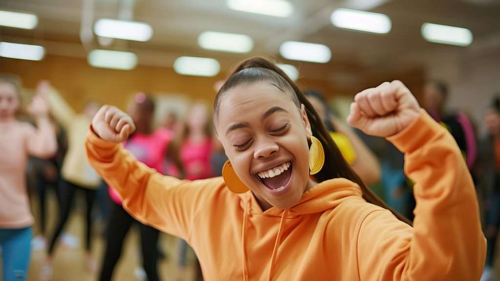 A young woman is smiling and stretching. Behind and out of focus is a group of people.