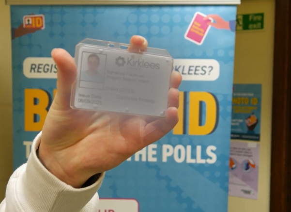 A hand holding an ID card.
