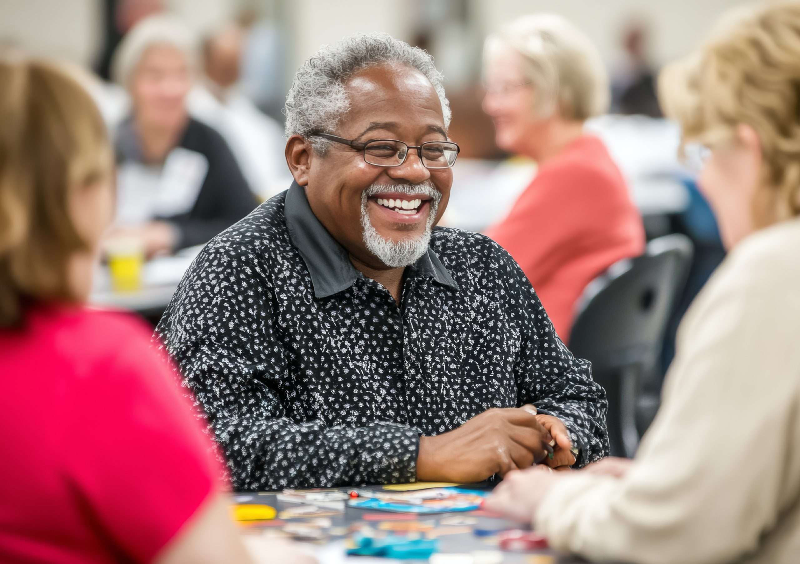 older people in a community centre. They are laughing and chatting.