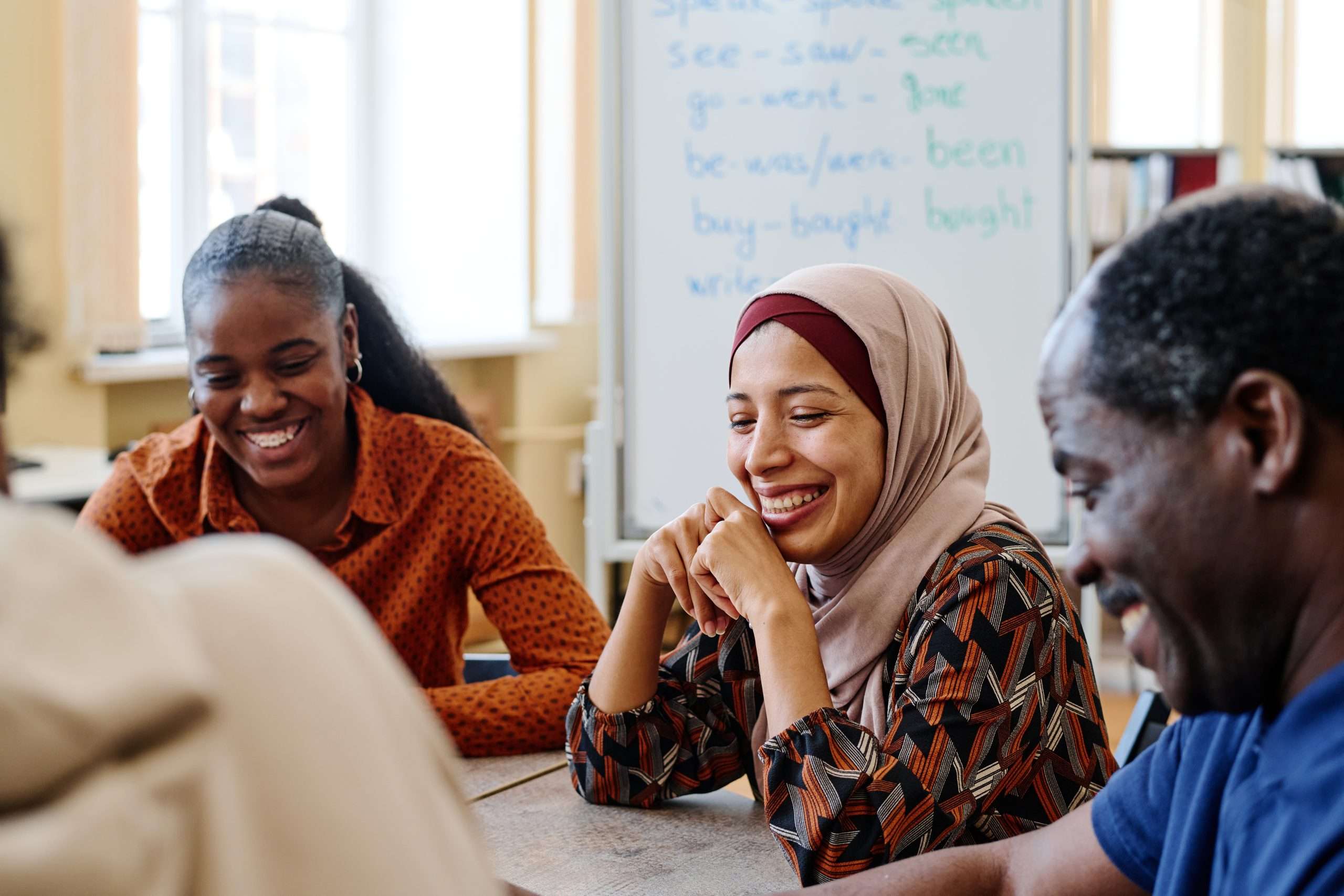 A diverse group of people sat around a table in a meeting.